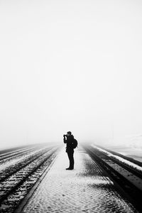 Man on snowy field against clear sky