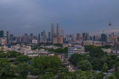 View of buildings in city against cloudy sky