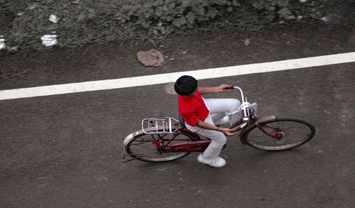 High angle view of man riding bicycle on road