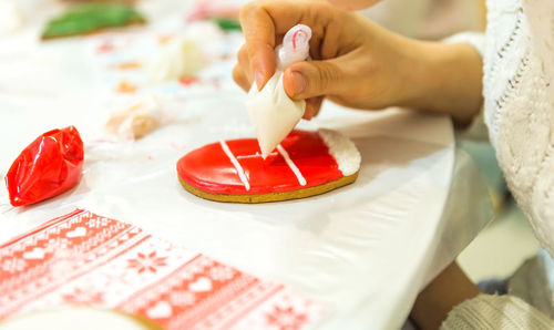 Close-up of hand holding ice cream on table