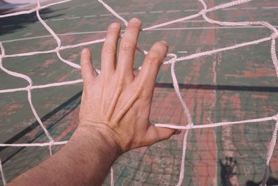 Close-up of hand holding sports net