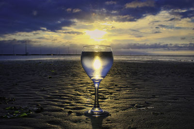 Light bulb on beach against sky during sunset