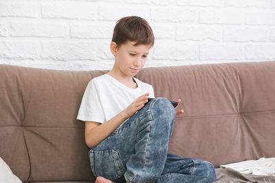 Young woman sitting on sofa at home