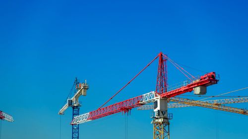 Low angle view of crane against blue sky