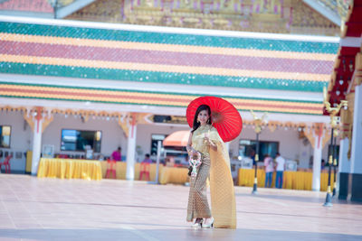 Woman with red umbrella standing at music concert