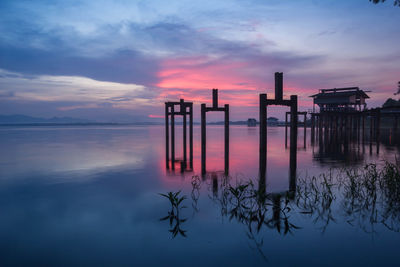 Pier on sea against sky during sunset