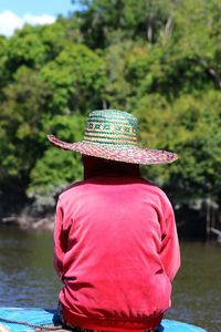 Rear view of woman standing against river