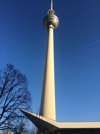 Low angle view of communications tower against blue sky