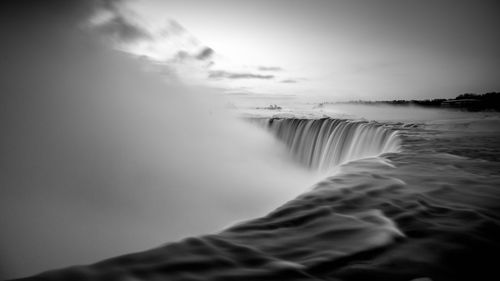 Scenic view of waterfall against sky