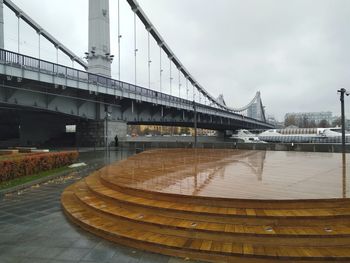 Bridge over river against cloudy sky