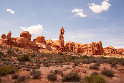 Rock formations on landscape against cloudy sky