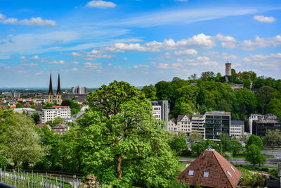 Trees and buildings against sky in city