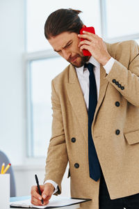 Businessman talking on phone while working at office