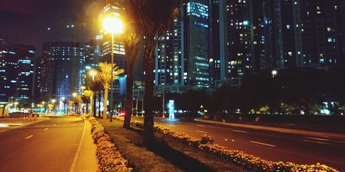 Illuminated city street and buildings at night