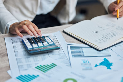 Midsection of businessman working on table