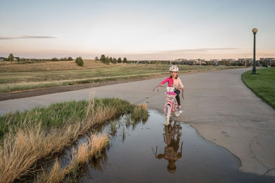 Portrait of woman riding horse in water against sky