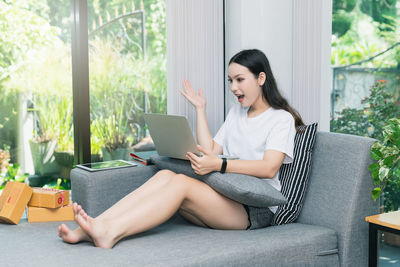 Young woman using mobile phone at home