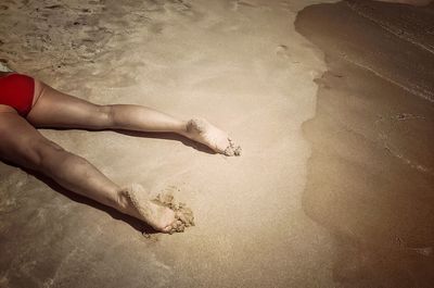 Low section of sunbather on beach