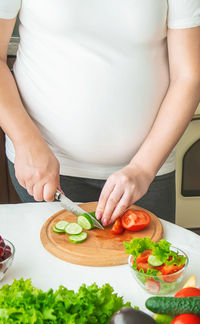 Pregnant woman chopping vegetable