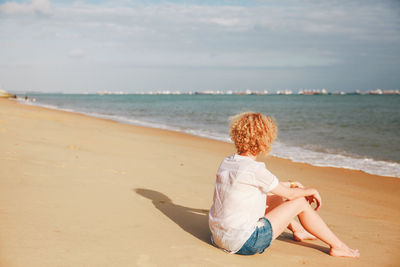 Rear view of people sitting on beach
