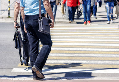 Low section of people crossing street in city