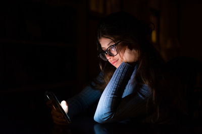 Young woman using mobile phone at home