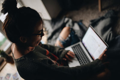 High angle view of woman using laptop at home