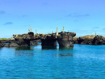 Built structure by sea against blue sky