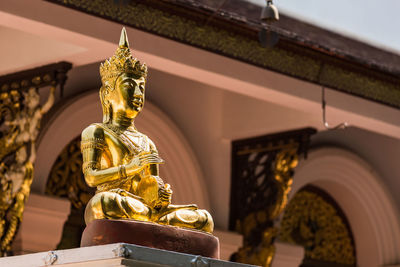 Statue outside temple against building