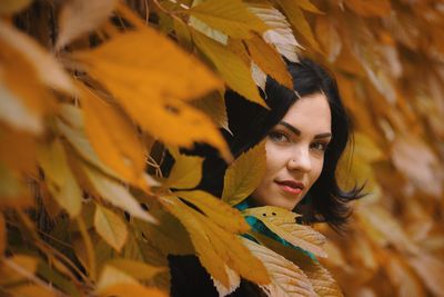 Portrait of beautiful woman amidst autumn leaves