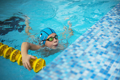 Boy in the pool. the face of a boy in swimming goggles and a swimming cap. 