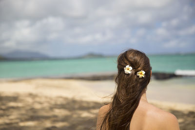 Rear view of woman standing on the beach