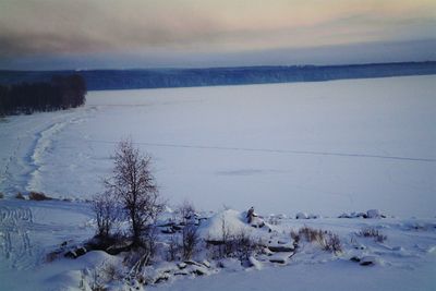 Scenic view of snow covered field against sky