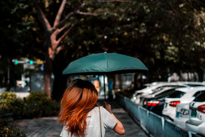 Rear view of woman with umbrella in rain