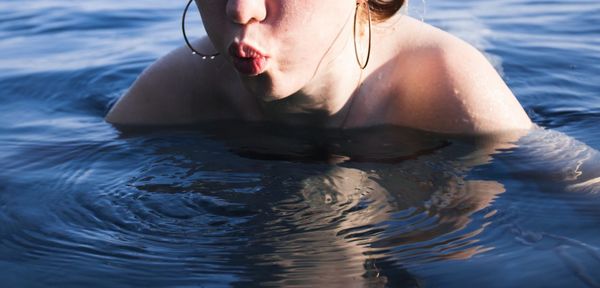 Midsection of woman swimming in sea