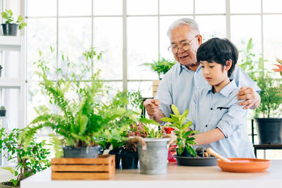 Friends standing by potted plants