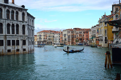 Boats in canal amidst buildings in city