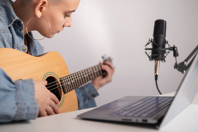 Midsection of man playing guitar