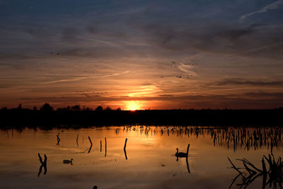 Scenic view of lake against sky during sunset