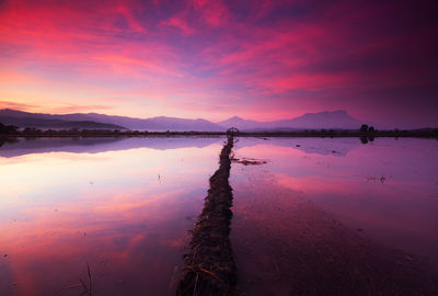 Scenic view of lake against romantic sky at sunset