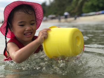 Girl playing with bucket at beach