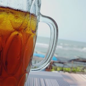 Close-up of drink on table against sea