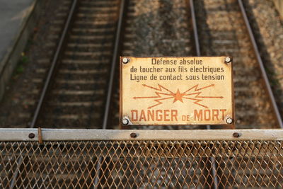Close-up of warning sign on chainlink fence