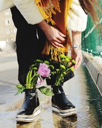 Low section of woman standing on footpath