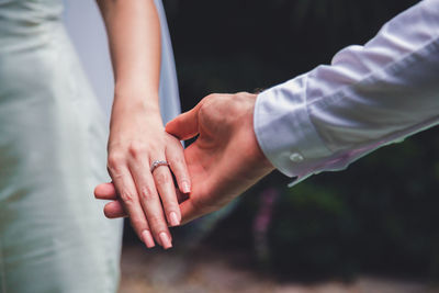 Midsection of couple holding hands