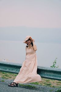 Woman standing by sea against sky