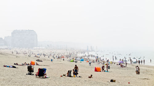 People at beach against clear sky