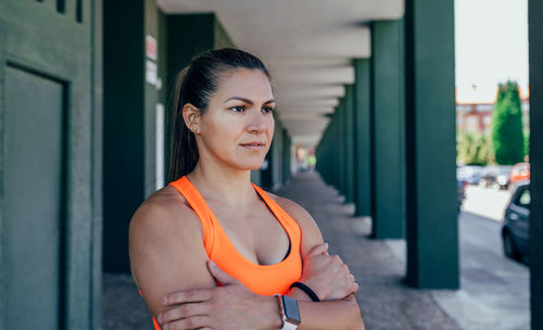 Thoughtful female athlete standing in corridor