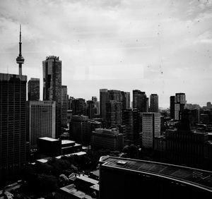 Modern buildings in city against cloudy sky