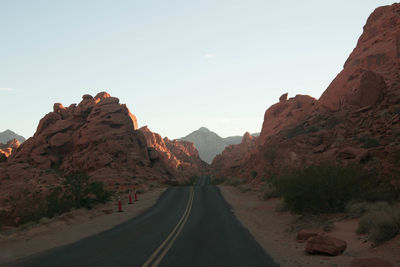 Road amidst mountains against clear sky